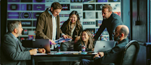 A PepsiCo creative team gathers around a meeting table, considering ideas.