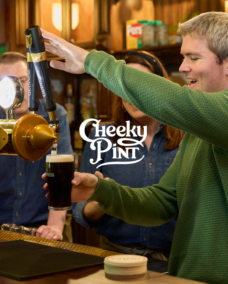Stripe cofounder John Collison pouring a pint of Guinness from a tap in a pub, smiling, with the 'Cheeky Pint' logo overlaid.