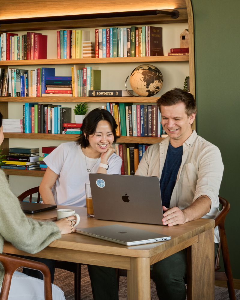 Two colleagues sharing a laptop in a library